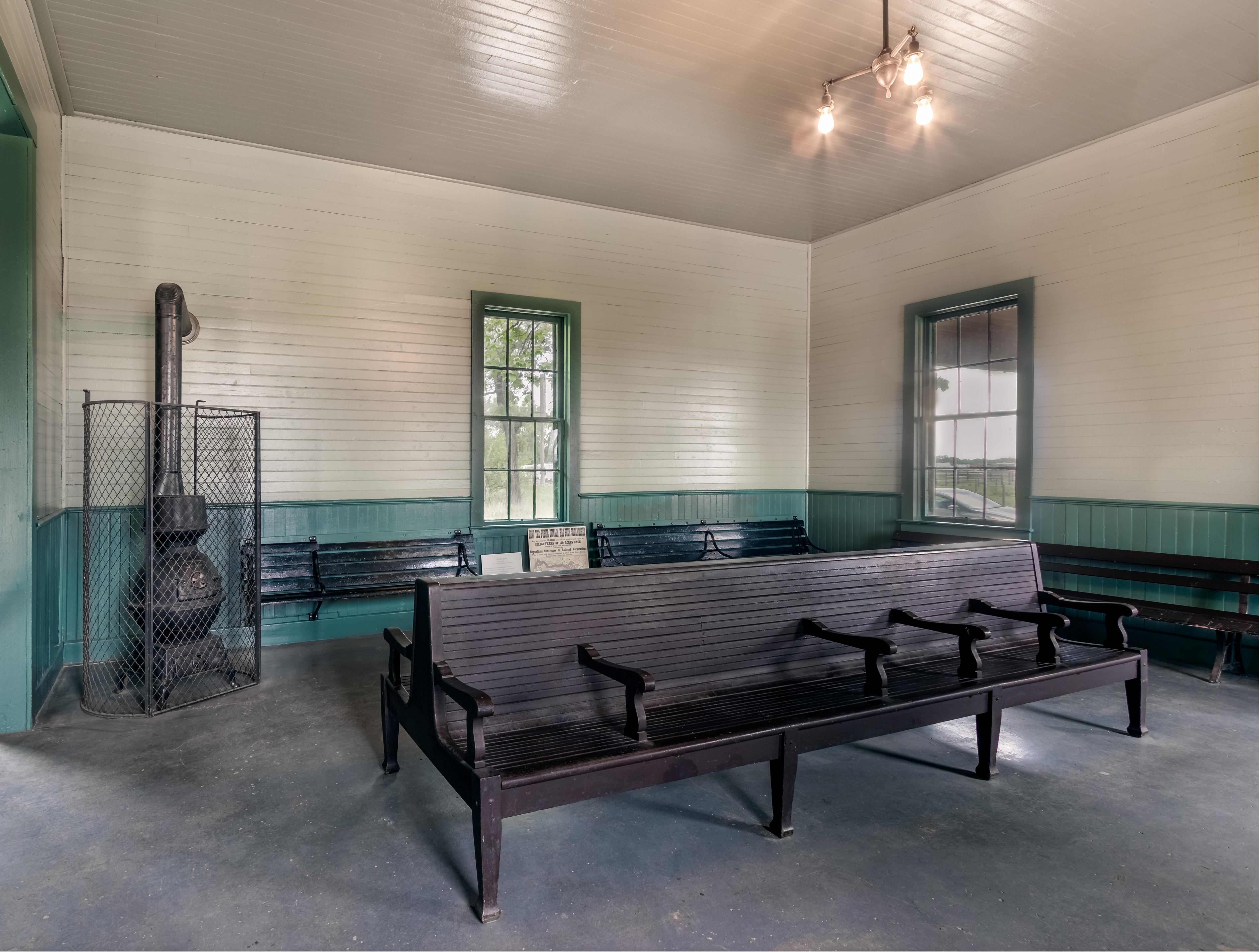 seating area in the Burlington Depot with two benches and a warming stove.