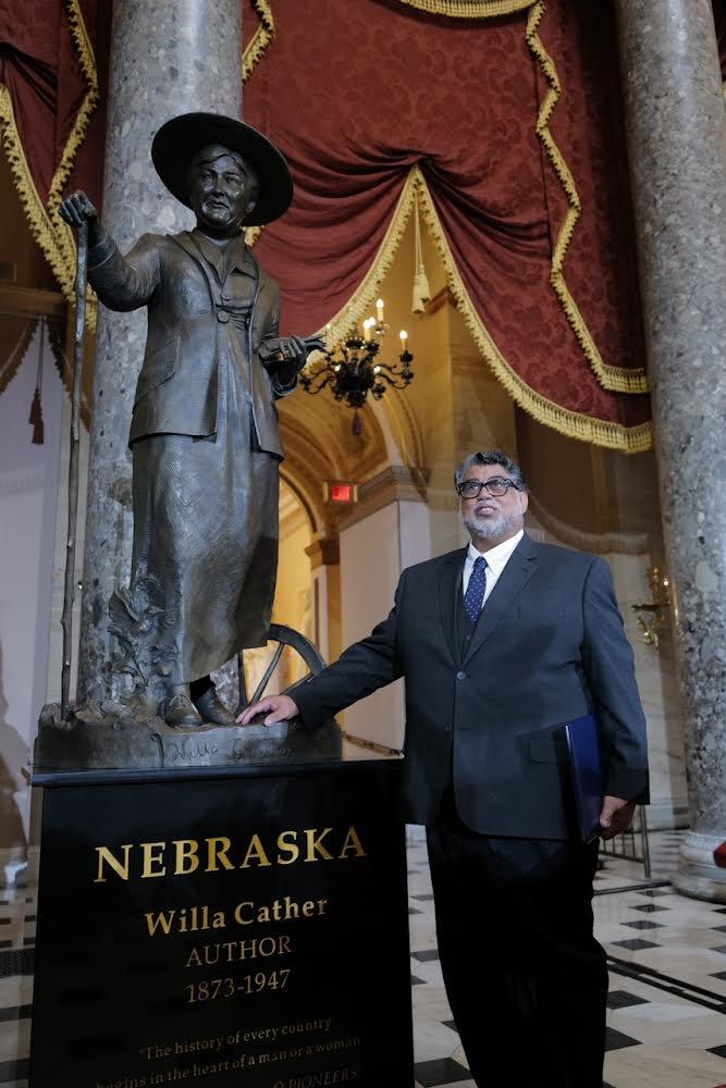 Littleton Alston stands next to his statue of Willa Cather on June 7, 2023