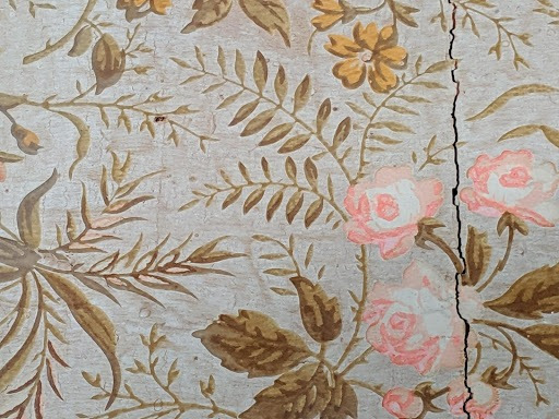Willa Cather's wallpaper: pink roses, white background, and green and brown foliage
