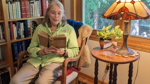 Abbie Loomis sits in her reading chair holding her mother's copy of My Antonia