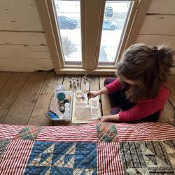 Conservator sits on the floor of the attic with toner examples.