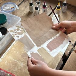 A conservator holds up toner examples to the light.