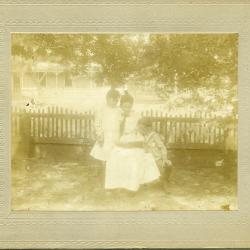 Pulitzer prize-winning author Willa Cather, reading to her younger sister Elsie (standing) and younger brother Jack (kneeling) at what we now call the Cather Childhood Home.  The Cathers lived in the Childhood Home from 1884 until 1903.