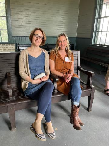 Two women sit on a bench in the Burlington Depot