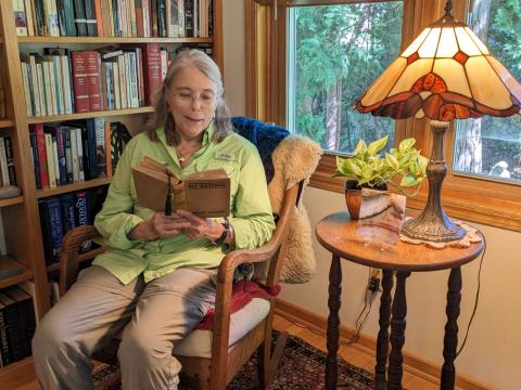 Abbie Loomis sits in her reading chair holding her mother's copy of My Antonia